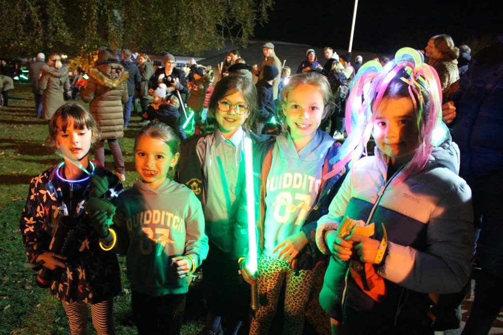 students holding up light sticks