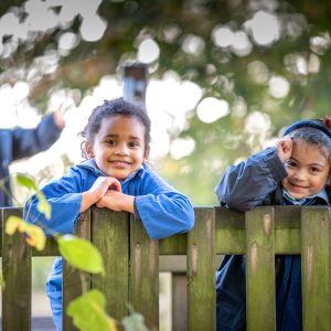 pupils leaning on a fence