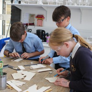 3 students working with wood