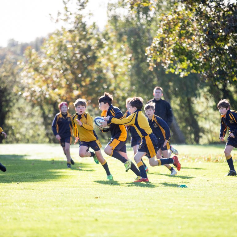 school children running across the pitch
