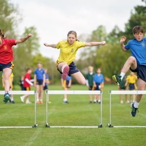 children running over hurdles