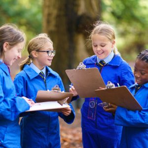 students writing onto clipboards