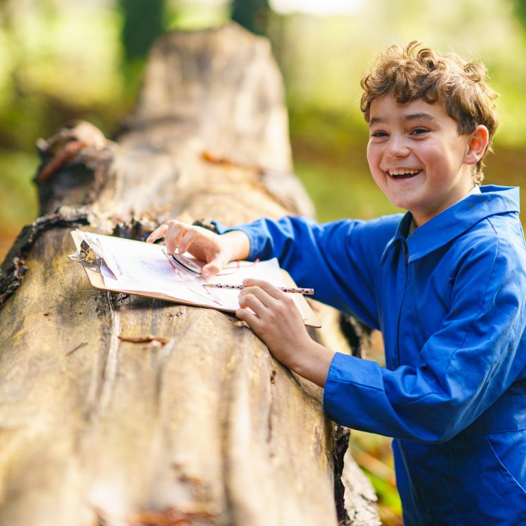 child using compass with a piece of paper to make notes