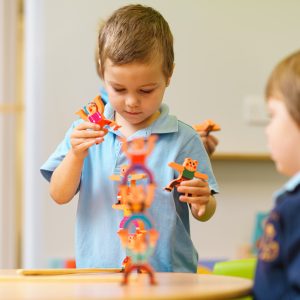 boy stacking wooden toys