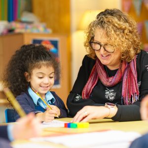 child and teacher working on work together