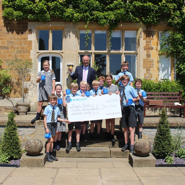 students holding a big cheque