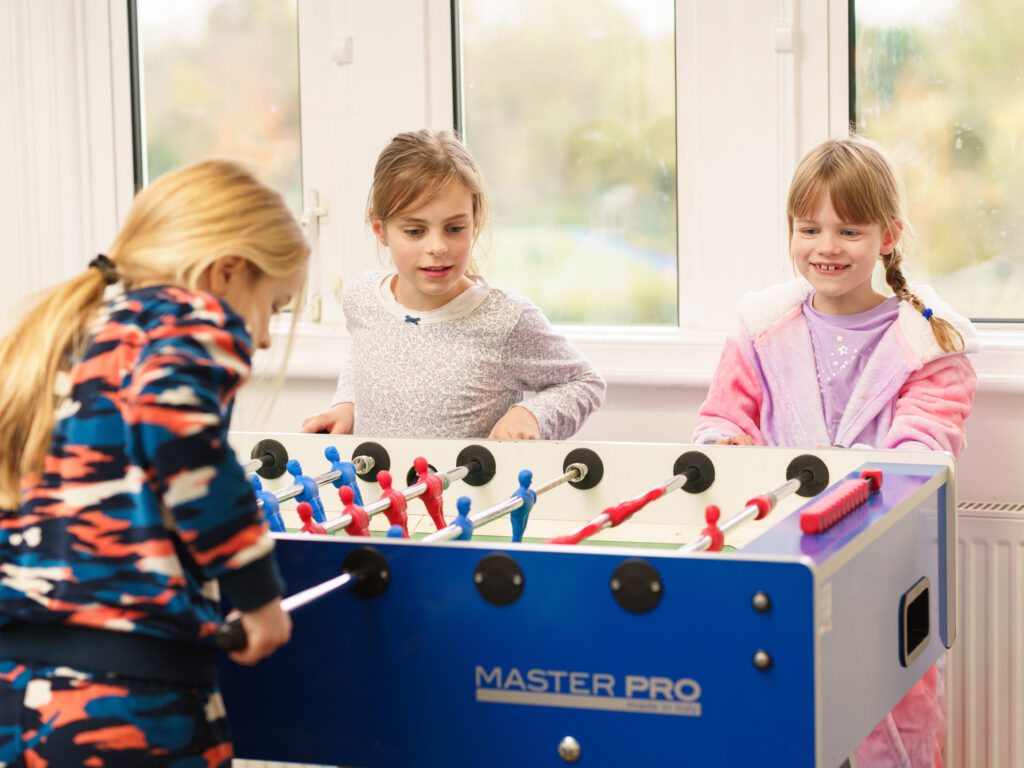 Girls playing Foosball in boarding house.