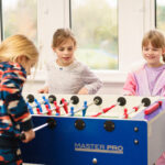 Girls playing Foosball in boarding house.