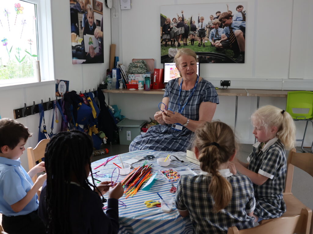 Wraparound Care leader teaching children how to make crafts on World Ocean Week