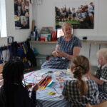 Wraparound Care leader teaching children how to make crafts on World Ocean Week