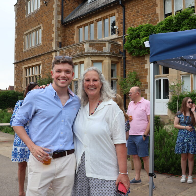 Teacher with former pupil at alumni event