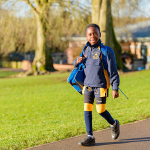 Boy walking to school in front of lawn on way in to Beachborough prep