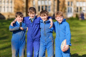 Boys supporting each other playing rugby at breaktime