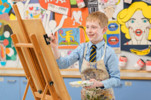 pupil painting on artists easel at Beachborough Prep