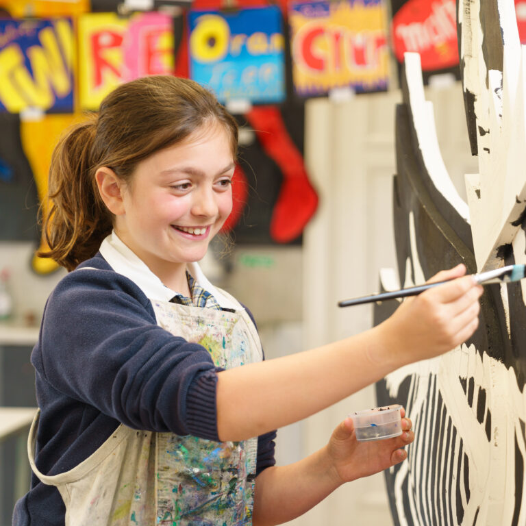 Girl painting swan for community outreach project